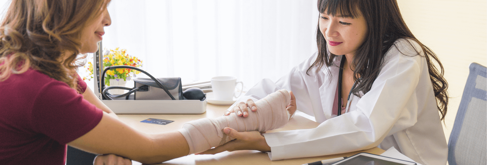 Doctor looking at patient's arm in cast