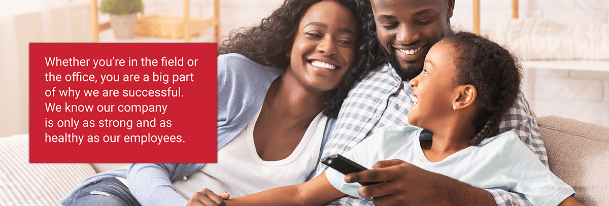 Family laughing on couch with red banner overlay that says "Whether you're in the field or the office, you are a big part of why we are successful. We know our company is only as strong and as healthy as our employees."